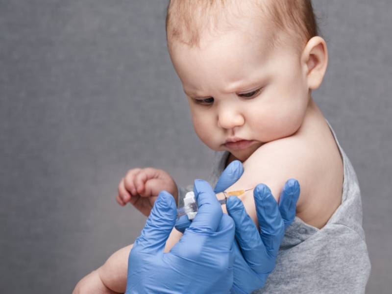 Pediatrician or nurse giving an intramuscular injection of a vac